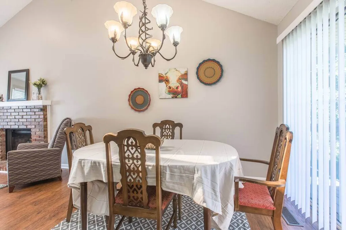 This image features a cozy dining area with a dining table, elegant chandelier, and warm accents like a fireplace and wall art. The table is set for family dinners or casual gatherings, echoing the convivial spirit of shared meals and lively conversation mentioned in the section.